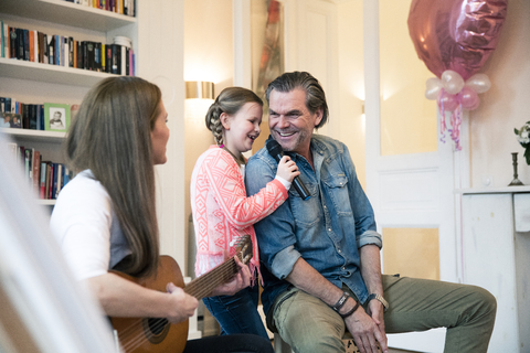 Glückliche Familie beim gemeinsamen Musizieren zu Hause, lizenzfreies Stockfoto