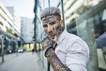 Young businessman with tattooed face walking in the city, portrait - ZEDF01340