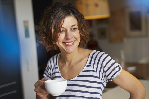 Porträt einer entspannten reifen Frau mit einer Tasse Kaffee zu Hause, lizenzfreies Stockfoto