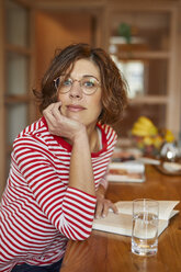 Portrait of mature woman with book at home - PNEF00628