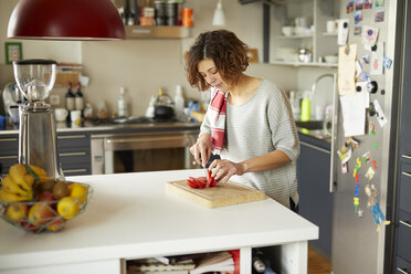 Mature woman cutting tomato in kitchen - PNEF00634