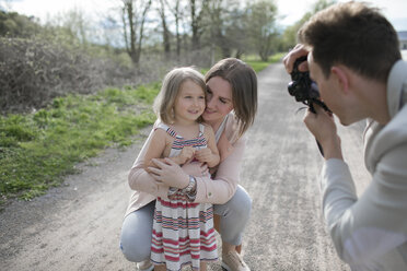 Junger Mann, der seine Familie mit der Kamera fotografiert - KMKF00234