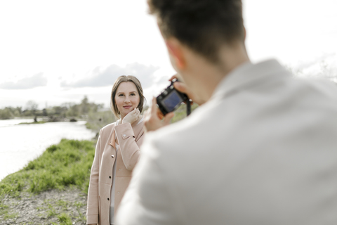 Junger Mann, der seine Freundin mit der Kamera fotografiert, lizenzfreies Stockfoto