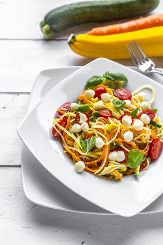 Zoodles mit Spaghetti, Tomaten und Mini-Mozzarella-Käsebällchen, lizenzfreies Stockfoto