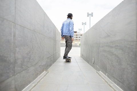 Junger Mann auf dem Skateboard in der Stadt, lizenzfreies Stockfoto