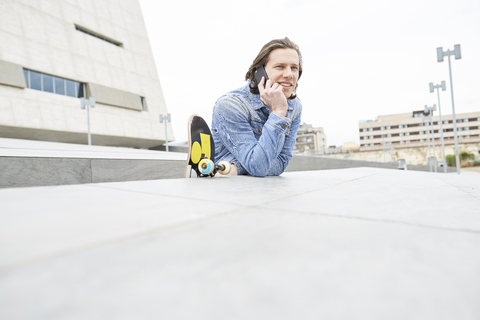 Junger Mann in der Stadt beim Telefonieren, lizenzfreies Stockfoto