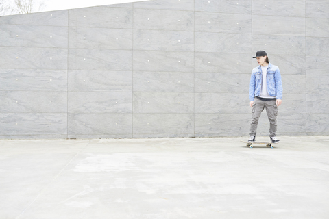 Junger Mann auf dem Skateboard in der Stadt, lizenzfreies Stockfoto