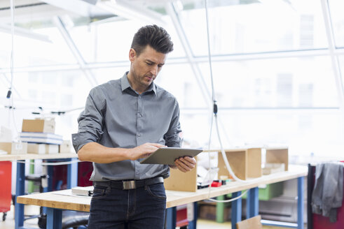 Mann benutzt Tablet in Fabrik - DIGF04004