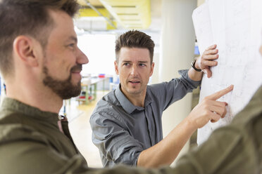 Zwei Männer besprechen einen Plan in einer Fabrik - DIGF04009