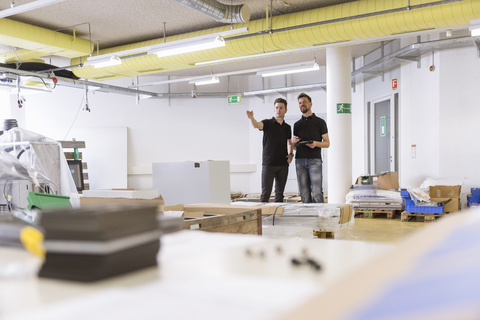 Two men talking in factory stock photo