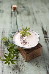 Glass bottle of woodruff sirup and bowl of natural yoghurt with chia and woodruff sirup - MYF02030