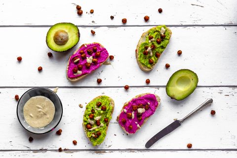 Baguette mit Guacomole und Rote-Bete-Hummus, gerösteten Kichererbsen und Tahin-Dressing, lizenzfreies Stockfoto