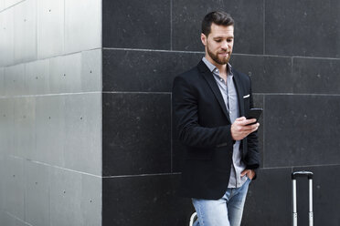 Young businessman looking at his smartphone - JSMF00151