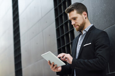 Young businessman looking at his digital tablet - JSMF00152