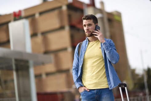 Junger Mann mit Smartphone am Bahnhof - JSMF00159