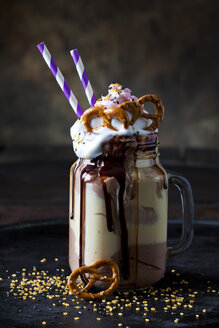 Glass of vanilla milkshake with cacao, chocolate sauce, whipped cream and topping - CSF29102