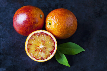 Two whole and a half blood orange on dark ground - CSF29110