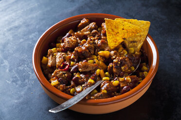 Vegetarian Chili with soy meat cut into strips and tortilla chips in earthenware dish - CSF29116