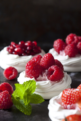 Meringue pastries garnished with whipped cream and raspberries stock photo