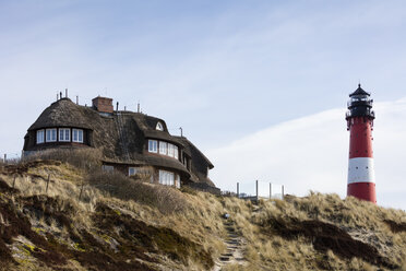 Deutschland, Schleswig-Holstein, Sylt, Hörnum, Reetdachhaus und Leuchtturm - WIF03508