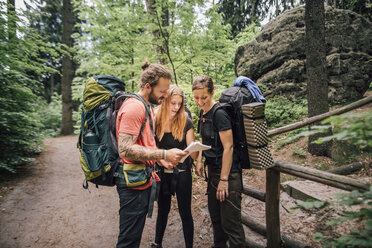 Friends on a hiking trip reading map - GUSF00723