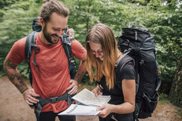 Happy young couple on a hiking trip reading map - GUSF00725