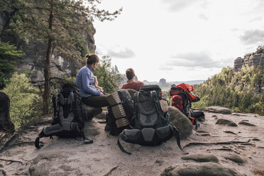 Germany, Saxony, Elbe Sandstone Mountains, friends on a hiking trip having a break - GUSF00728