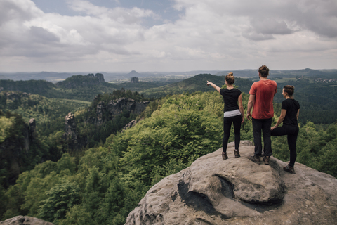 Deutschland, Sachsen, Elbsandsteingebirge, Wanderfreunde auf einem Felsen stehend, lizenzfreies Stockfoto