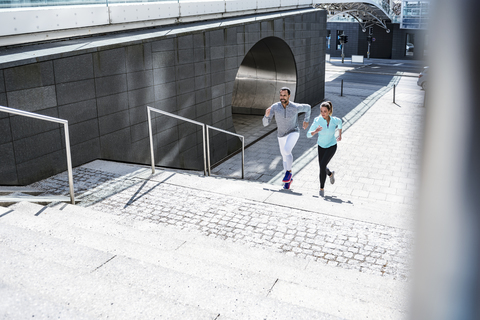 Pärchen läuft auf einer Treppe in der Stadt, lizenzfreies Stockfoto