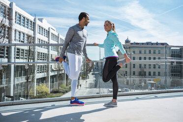 Couple doing stretching exercise on bridge in the city - DIGF04043