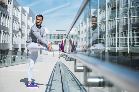 Man doing stretching exercise in the city stock photo