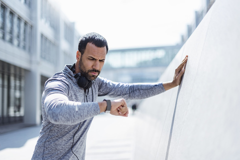 Man having a break from exercising looking on smartwatch stock photo