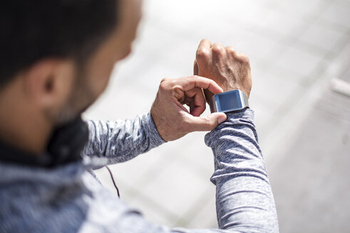 Close-up of athlete checking smartwatch - DIGF04054