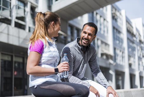 Aktives Paar mit Wasserflasche bei einer Pause in der Stadt - DIGF04062