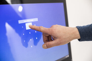 Businessman entering PIN code on touch screen - FMKF05026