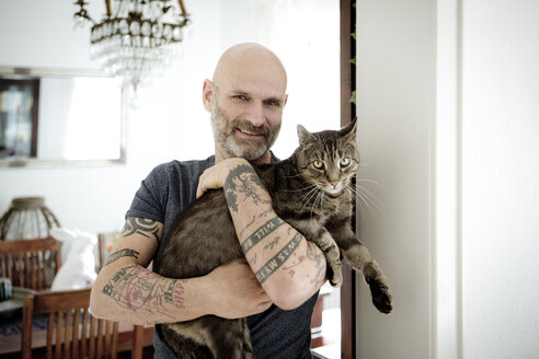 Tattooed man carrying his cat - FLLF00021