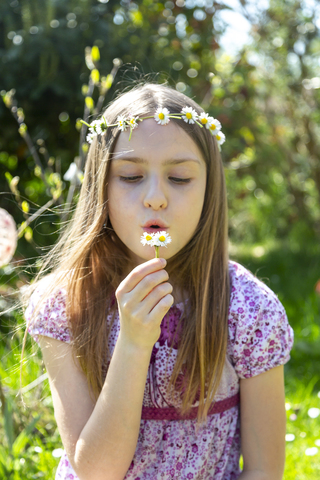 Porträt eines Mädchens mit Gänseblümchen im Garten, lizenzfreies Stockfoto