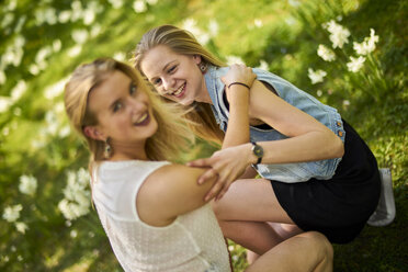 Two friends relaxing together on flower meadow - BEF00009