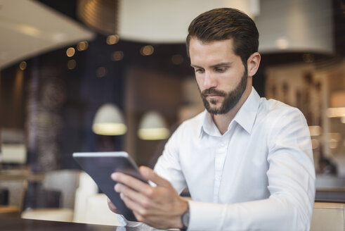 Junger Geschäftsmann benutzt Tablet in einem Café - DIGF04081