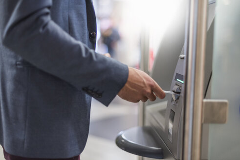 Nahaufnahme eines Geschäftsmannes, der an einem Geldautomaten Geld abhebt - DIGF04088