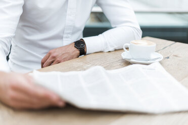 Nahaufnahme eines Geschäftsmannes beim Zeitungslesen in einem Café - DIGF04111