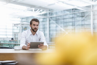 Young businessman using tablet in a cafe - DIGF04116