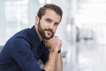 Portrait of confident young businessman sitting in waiting area - DIGF04125