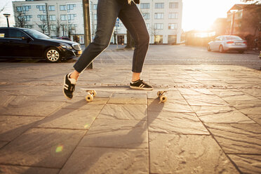 Niedriger Ausschnitt eines jugendlichen Mädchens beim Skateboardfahren auf dem Bürgersteig an einem sonnigen Tag - MASF07088