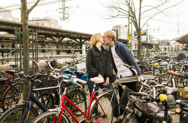 Junges Paar küsst sich auf einem Fahrradparkplatz - MASF07106
