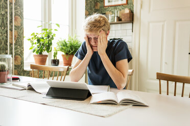 Young man studying with head in hands at home - MASF07113