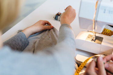 Cropped image of young couple at sewing machine - MASF07121