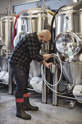 Manager bei der Arbeit am Lagertank einer Brauerei in voller Länge - MASF07161