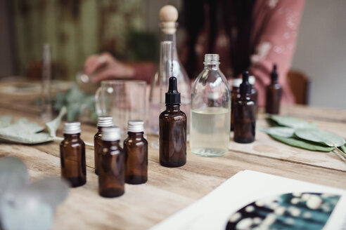 Mittelteil einer Unternehmerin bei der Parfümherstellung am Tisch in einer Werkstatt - MASF07182