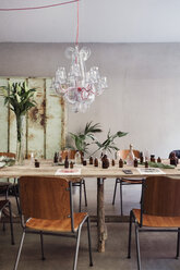 Perfume bottles on table amidst chairs at workshop - MASF07231